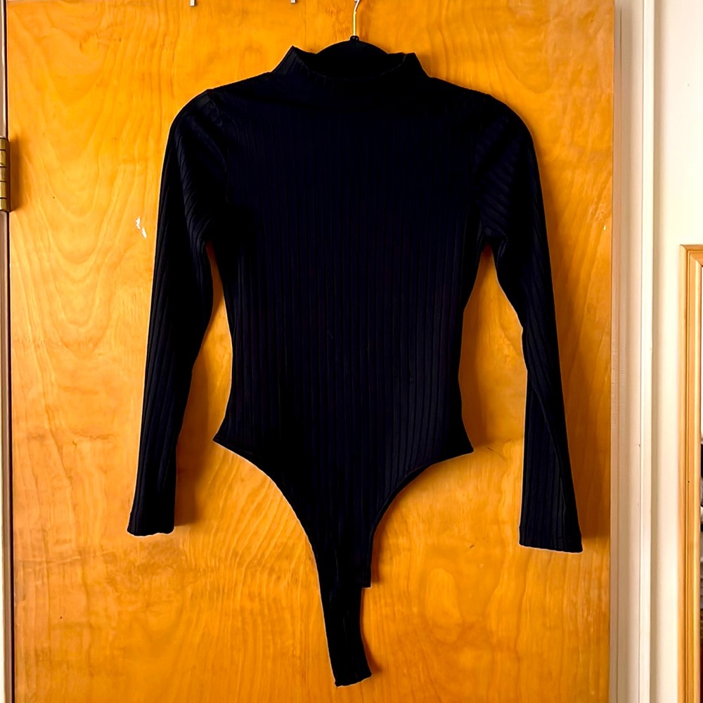 Long sleeve high neck black thong body suit by Eva Mendes.
